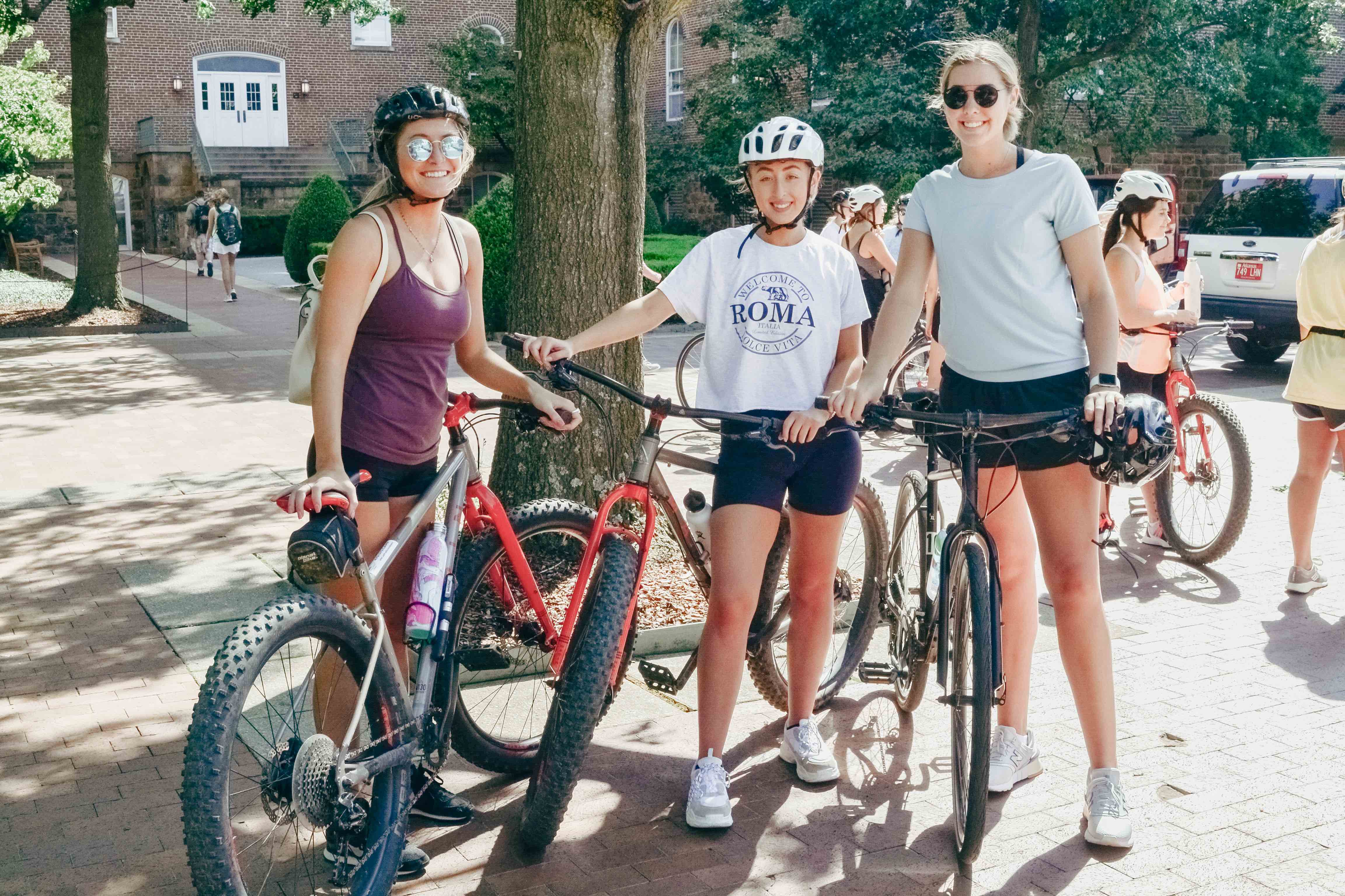 three women getting ready to ride mountain bikes and hybrid bikes