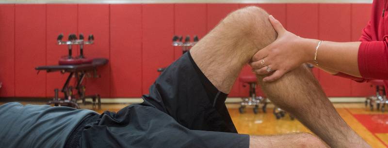 UREC Sports Injury Clinic avery checks patient's acl